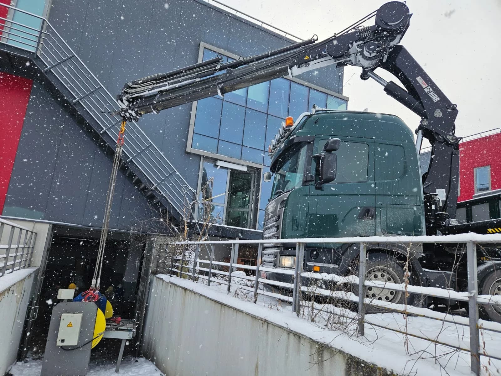 Automacara SCANIA verde cu macaraua ridicată, iarna